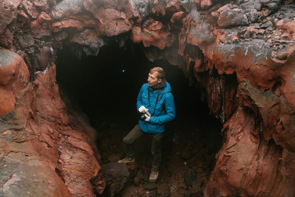 Adventure seeker explores deep cave with intriguing geological formations.